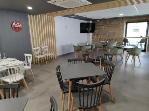 a dining room with tables and chairs and a brick wall at A Quinta de Cea in Cea
