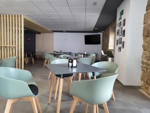 a dining room with tables and chairs and a tv at A Quinta de Cea in Cea