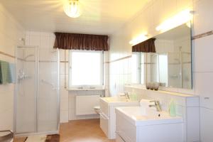 バート・フュッシンクにあるAparthotel Naturidyll - Wieserhofのバスルーム(洗面台2台、シャワー、鏡付)