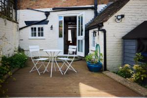 a patio with a table and chairs in front of a house at The Old Hatfield Haven - Spacious 6BDR House with Garden in Hatfield