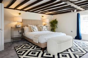 1 dormitorio con 1 cama grande y 1 silla en The Old Hatfield Haven - Spacious 6BDR House with Garden en Hatfield
