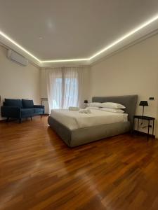 sypialnia z łóżkiem i kanapą oraz drewnianą podłogą w obiekcie Lux apartment San Paolo w Rzymie