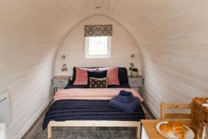 Tempat tidur dalam kamar di The Downs Stables Glamping Pod Theos Charm