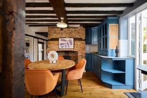 a kitchen with blue cabinets and a table and chairs at The Old Hatfield Haven - Spacious 6BDR House with Garden in Hatfield