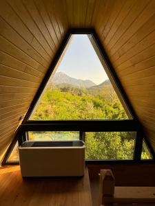 a large window in a room with a view of the mountains at Trinitys Forest Bungalows in Kemer