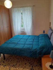 a blue bed in a bedroom with a window at Profumo di montagna San Giacomo di roburent in San Giacomo