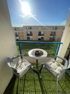 a balcony with two chairs and a table and a table at Logement Cosy pour Deux ou Trois - Parfait pour les Jeunes ou Étudiants in Montpellier
