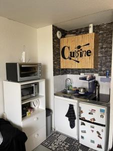 a small kitchen with a counter and a microwave at Logement Cosy pour Deux ou Trois - Parfait pour les Jeunes ou Étudiants in Montpellier