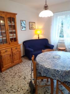 a living room with a table and a blue couch at Profumo di montagna San Giacomo di roburent in San Giacomo