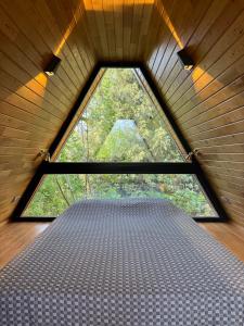 ein großes Fenster in einem Zimmer mit einer Matratze in der Unterkunft Trinitys Forest Bungalows in Kemer