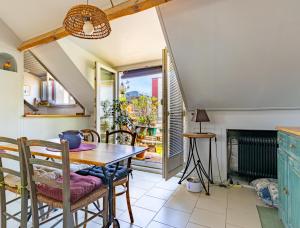 蒙特勒伊的住宿－Aux Portes de Paris, charme avec balcon sous les combles，一间带桌子和壁炉的用餐室
