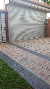 a garage with a door and a grass yard at Jet Winner Sky in Wattala