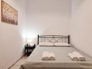 a bedroom with a bed with two towels on it at Sophie's Pourko House in Kythira
