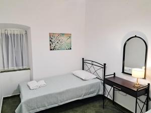 a bedroom with a bed and a mirror and a table at Sophie's Pourko House in Kythira