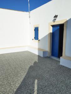a room with a blue door and a building at Sophie's Pourko House in Kythira