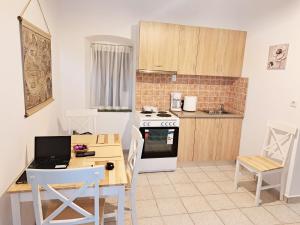 a kitchen with a table and a laptop on a desk at Sophie's Pourko House in Kythira