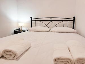 a white bed with white sheets and pillows at Sophie's Pourko House in Kythira