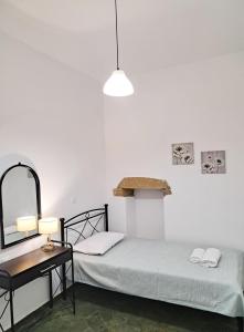 a bedroom with a bed and a table and a mirror at Sophie's Pourko House in Kythira
