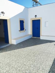 a room with two blue doors on a white wall at Sophie's Pourko House in Kythira
