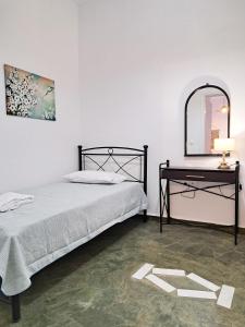 a bedroom with a bed and a table with a mirror at Sophie's Pourko House in Kýthira