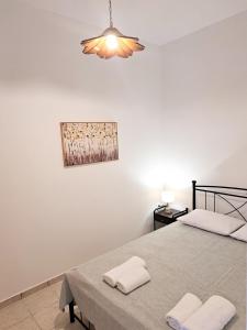 a bedroom with a bed and a painting on the wall at Sophie's Pourko House in Kythira