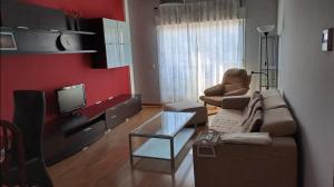 een woonkamer met een bank en een tv bij Apartamento Pinseque in Pinseque
