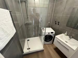 uma casa de banho com uma cabina de duche em vidro e uma máquina de lavar roupa em Zentrale Apartments in Bayreuth em Bayreuth