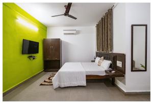 a bedroom with a bed and a green wall at Palash Villa in Aguada