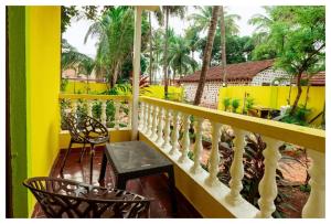 a balcony with a white railing and a table and chairs at Palash Villa in Aguada