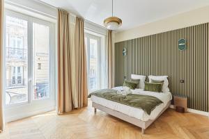 a bedroom with a bed and a large window at Apartement Place Vendome by Studioprestige in Paris