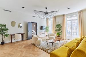 a living room with a yellow couch and a table at Apartement Place Vendome by Studioprestige in Paris