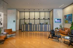 a lobby with a waiting area with chairs and tables at INNSiDE by Meliá München Parkstadt Schwabing in Munich