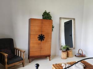 a wooden cabinet in a room with a chair and a mirror at Moongardenhouse in Kováčovce