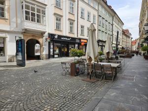 uma rua com mesas e guarda-sóis numa rua da cidade em Apartment Nina with private terrace Tour As Ljubljana em Ljubljana