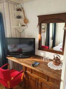 a room with a television on a dresser with a mirror at Gits Gard in Falkenberg
