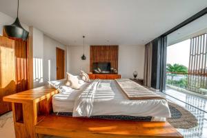 um quarto com uma cama grande e uma janela grande em Balangan Beach Villa Freya Jimbaran em Jimbaran