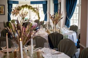 a dining room with tables and chairs with flowers at Himley House by Chef & Brewer Collection in Himley