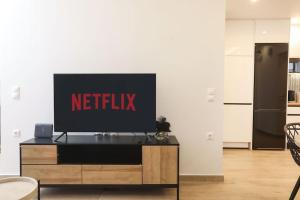 a television sitting on top of a wooden entertainment center at Venetian Canvas Retreat in Corfu