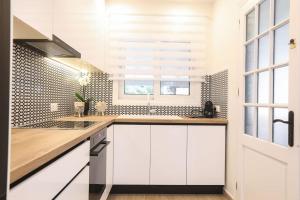 a kitchen with white cabinets and a window at Venetian Canvas Retreat in Corfu
