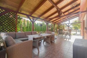 un patio con sofá, mesa y sillas en Villa Eszter, en Balatonkeresztúr