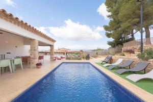 una piscina con sillas y una casa en El Secret De Marco en Vall dʼAlba