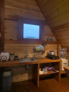 a kitchen with a sink and a window in a cabin at DIENG COTTAGE 2 in Dieng