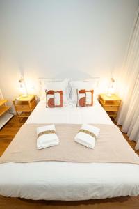 Un dormitorio con una gran cama blanca con dos mesitas de noche. en Casa Andrés Apartamento, en Oviedo
