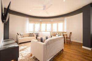 Una sala de estar con dos sofás blancos y una mesa. en Casa Andrés Apartamento, en Oviedo