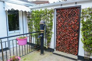 a fire hydrant in front of a house with a gate at Urban Nest Townhouse in Galway