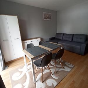 a living room with a table and chairs and a couch at Apartament Dunikowskiego 57m2 in Lublin