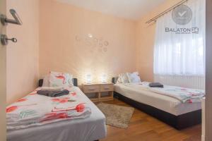 a bedroom with two beds and a window at Villa Eszter in Balatonkeresztúr +43 photos