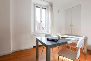 a table and chairs in a room with a window at HACCA Collection - Brera & Fashion District - Bright 2BR Apt in Milan
