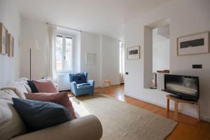 a living room with a couch and a tv at HACCA Collection - Brera & Fashion District - Bright 2BR Apt in Milan