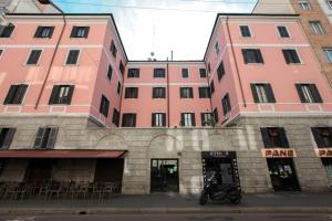 a motorcycle parked in front of two pink buildings at HACCA Collection - Brera & Fashion District - Bright 2BR Apt in Milan